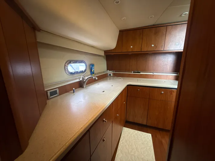 Relentless Yacht Photos Pics Luxurious 2006 Tiara Yachts 4300 Sovran kitchen with wood cabinetry and modern fixtures.