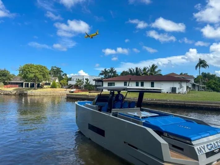  Yacht Photos Pics De Antonio Yachts D42 Open 2023 docked in a serene waterfront neighborhood.