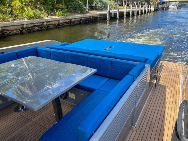  Yacht Photos Pics 2023 De Antonio Yachts D42 Open with blue seating and dining area on deck.