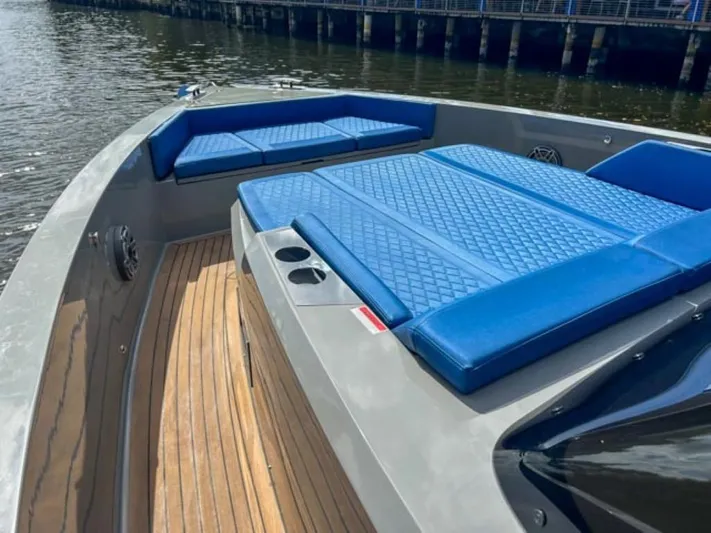  Yacht Photos Pics 2023 De Antonio Yachts D42 Open with blue cushioned seating and wooden deck.