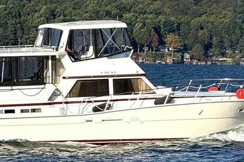  Yacht Photos Pics 1987 Viking 44 Motor Yacht cruising on a lake with forested shoreline.
