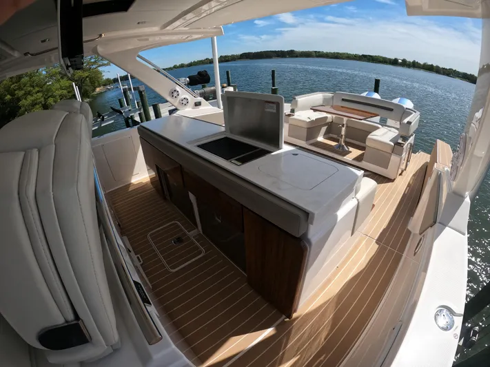  Yacht Photos Pics 2024 Tiara Yachts 43 LS luxury deck with seating and kitchenette, overlooking serene waters.