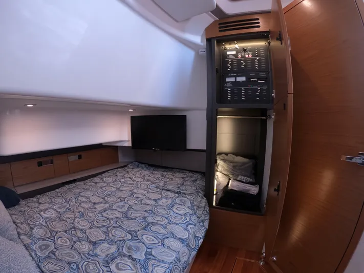  Yacht Photos Pics 2024 Tiara Yachts 43 LS cabin interior with bed, TV, and control panel.