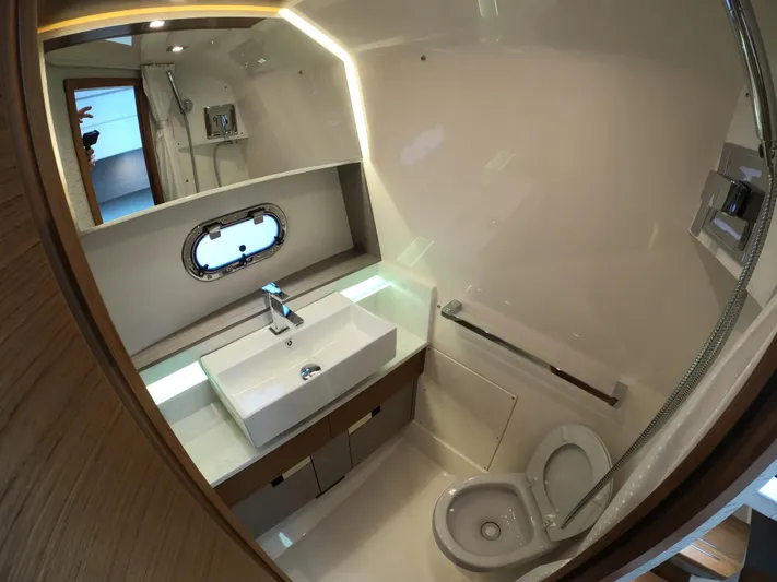  Yacht Photos Pics 2024 Tiara Yachts 43 LS bathroom with modern sink, toilet, and porthole window.