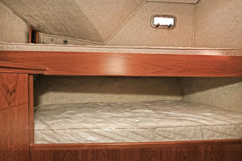 Journey Yacht Photos Pics Bunk beds in 2000 Torres 48 Enclosed Bridge yacht cabin, featuring wood finish and compact design.