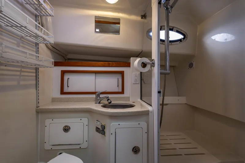 Ha Kin Yacht Photos Pics 2008 Back Cove 33 yacht bathroom with sink, shower, and storage shelves.