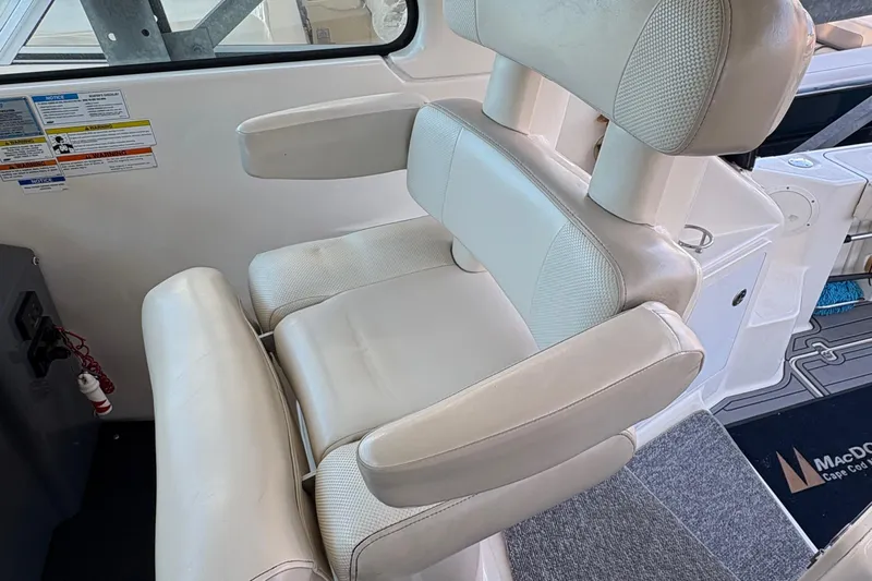  Yacht Photos Pics Captain's chair on 2013 Pursuit OS 315 Offshore boat, featuring white upholstery and armrests.