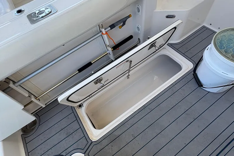  Yacht Photos Pics 2013 Pursuit OS 315 Offshore boat deck with open storage compartment and fishing gear.