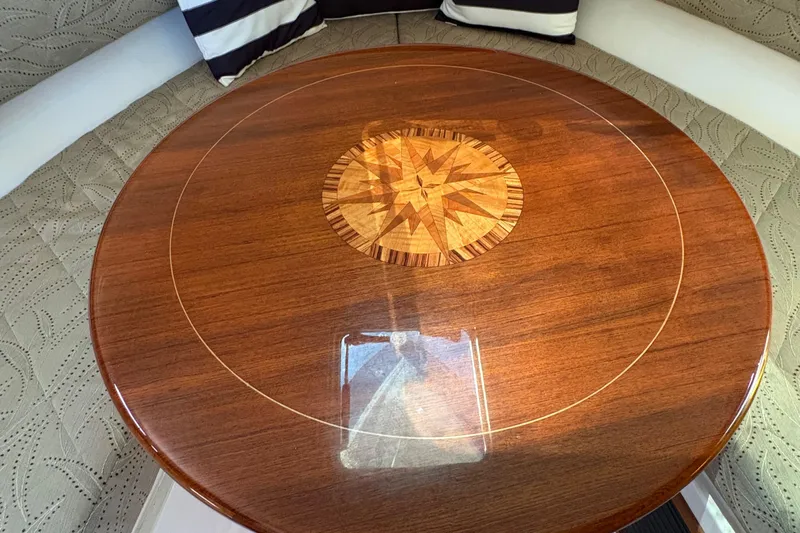  Yacht Photos Pics Luxurious wooden table with compass design in 2013 Pursuit OS 315 Offshore boat interior.