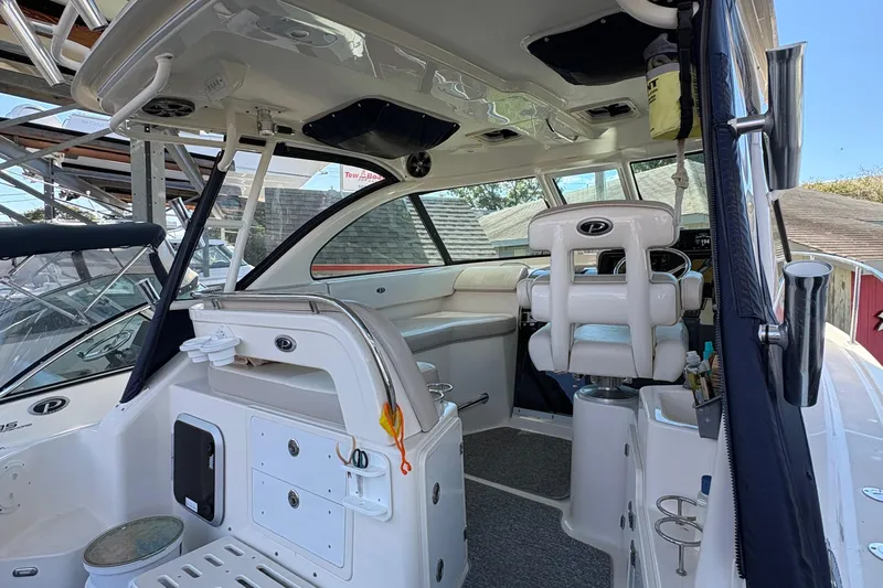  Yacht Photos Pics 2013 Pursuit OS 315 Offshore boat interior with helm and seating area.