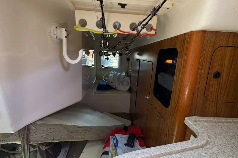  Yacht Photos Pics Interior of 2013 Pursuit OS 315 Offshore boat with wood paneling and fishing rods.