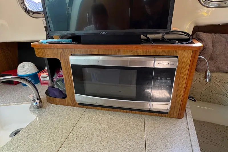  Yacht Photos Pics 2013 Pursuit OS 315 Offshore interior with Frigidaire microwave and Vizio TV.