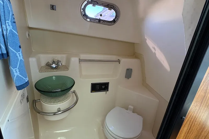  Yacht Photos Pics 2013 Pursuit OS 315 Offshore bathroom with glass sink and porthole window.