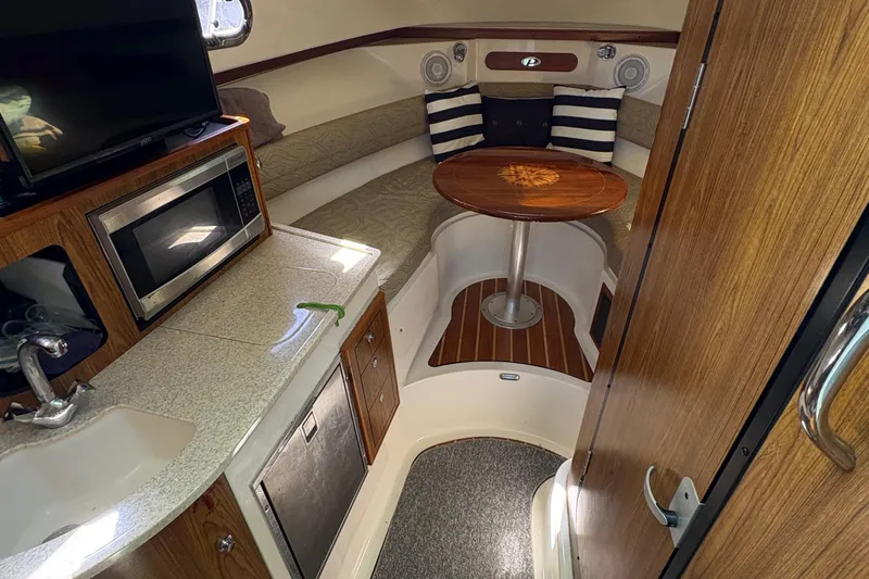  Yacht Photos Pics Interior of 2013 Pursuit OS 315 Offshore boat with kitchenette and seating area.