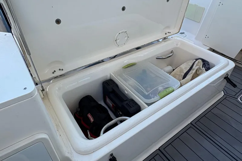  Yacht Photos Pics Open storage compartment on 2013 Pursuit OS 315 Offshore boat with various items inside.