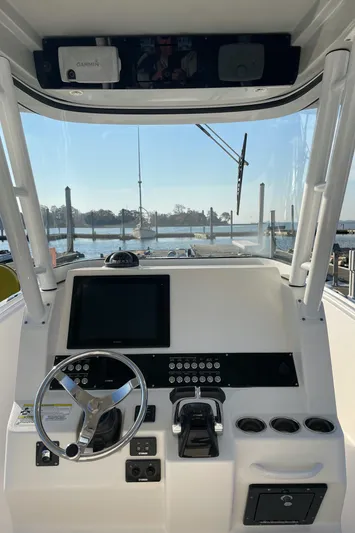  Yacht Photos Pics 2015 Edgewater 280CC boat dashboard with steering wheel and controls, docked by the water.
