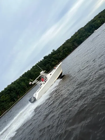  Yacht Photos Pics 2015 Edgewater 280CC boat cruising on a lake with forested shoreline.