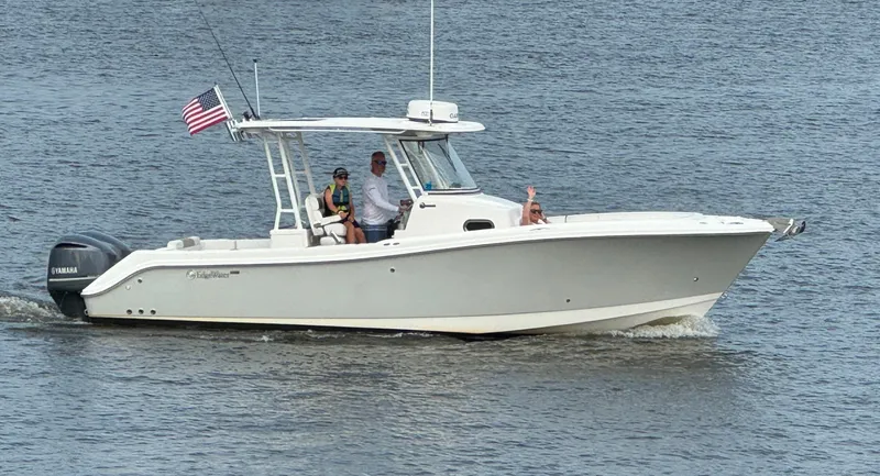  Yacht Photos Pics 2015 Edgewater 280CC boat cruising on water with passengers and American flag.