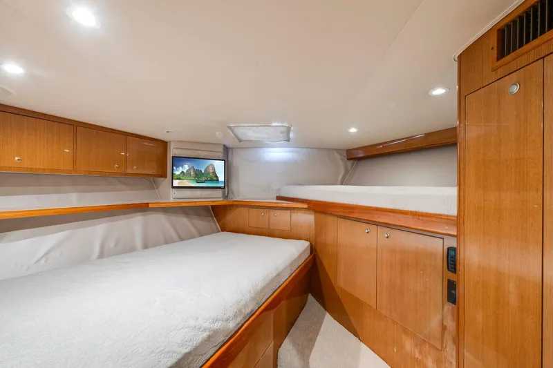  Yacht Photos Pics Luxurious 2002 Viking Convertible yacht cabin with wood finishes and cozy bedding.