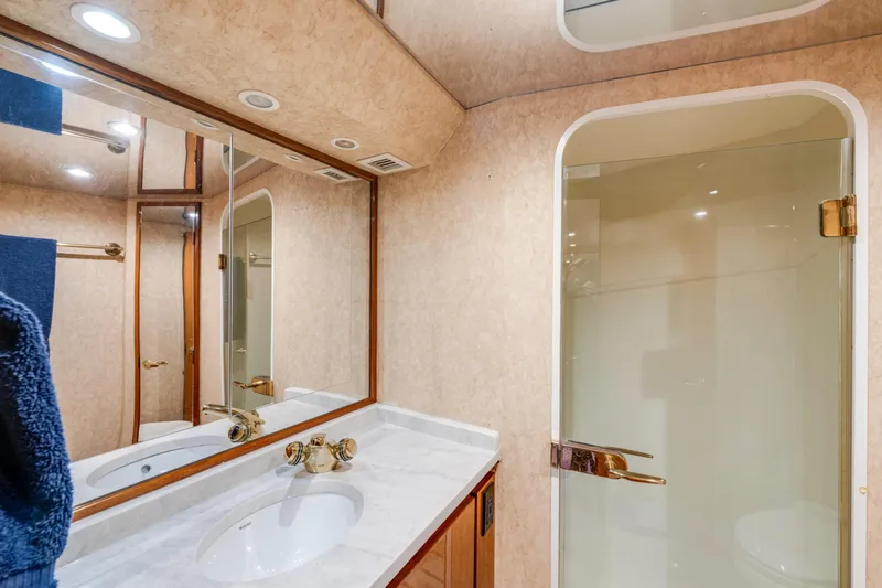  Yacht Photos Pics Luxurious bathroom in 2002 Viking Convertible yacht with marble countertop and glass shower.