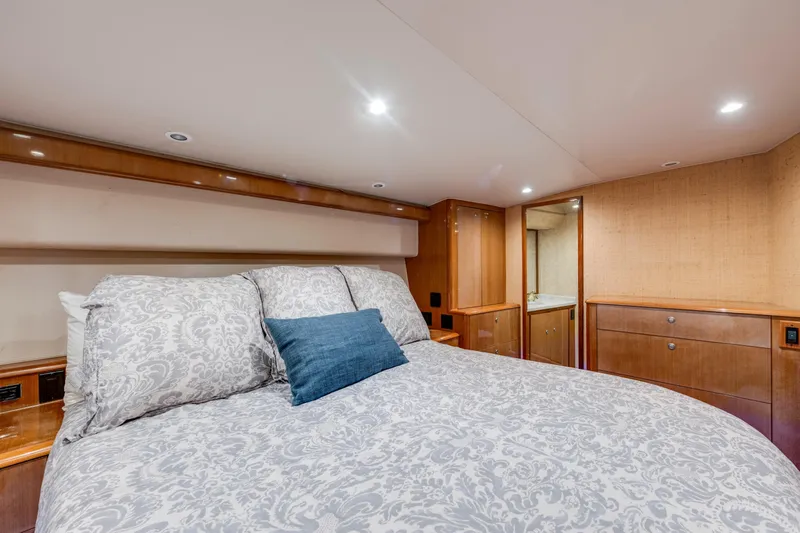  Yacht Photos Pics Luxurious bedroom interior of 2002 Viking Convertible yacht with elegant bedding and wood cabinetry.