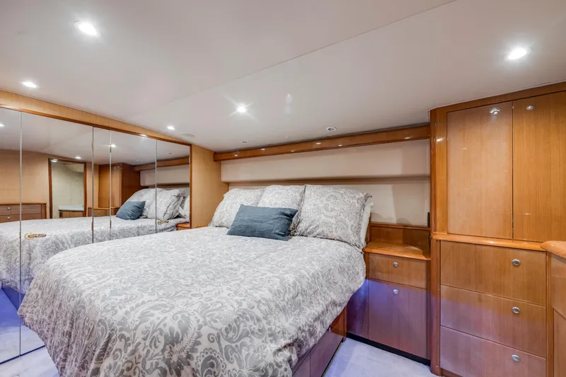  Yacht Photos Pics Luxurious bedroom interior in 2002 Viking Convertible yacht with elegant wood cabinetry and mirrored closet.