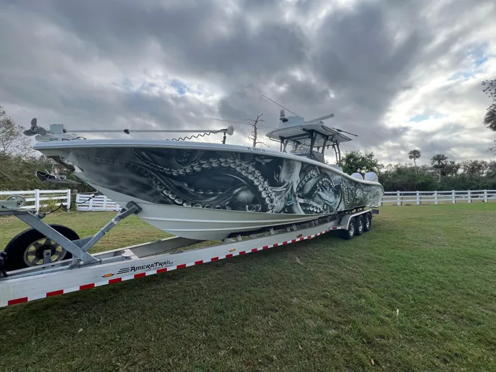  Yacht Photos Pics 2019 Yellowfin 36 Offshore boat with octopus design on trailer, cloudy sky background.