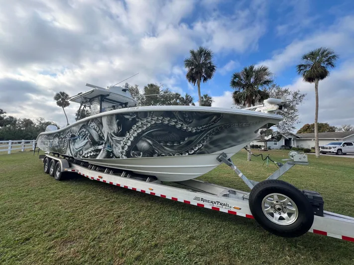  Yacht Photos Pics 2019 Yellowfin 36 Offshore boat with octopus artwork on trailer, under a partly cloudy sky.