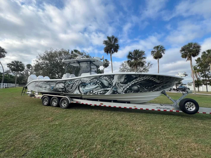  Yacht Photos Pics 2019 Yellowfin 36 Offshore boat with octopus artwork on trailer, surrounded by palm trees.