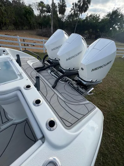  Yacht Photos Pics 2019 Yellowfin 36 Offshore boat with triple Mercury outboard engines, docked on grass.