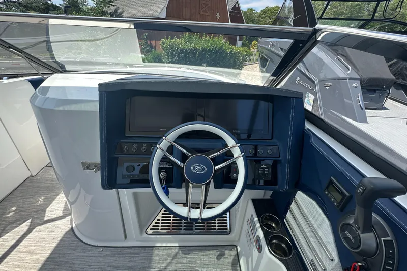  Yacht Photos Pics 2022 Cobalt A29 boat dashboard with steering wheel and control panel.