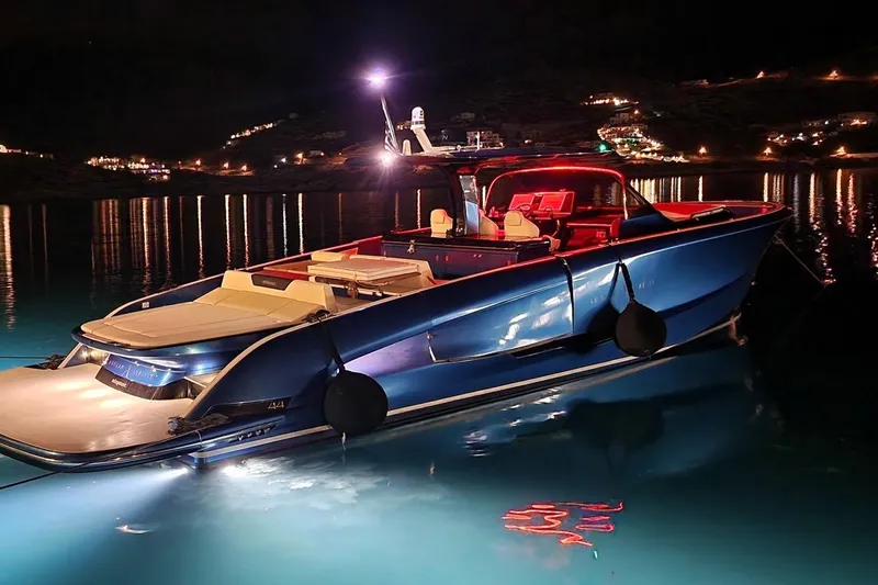 Aegean Infinity Yacht Photos Pics 2023 Solaris Power 44 Open yacht illuminated at night on calm waters.