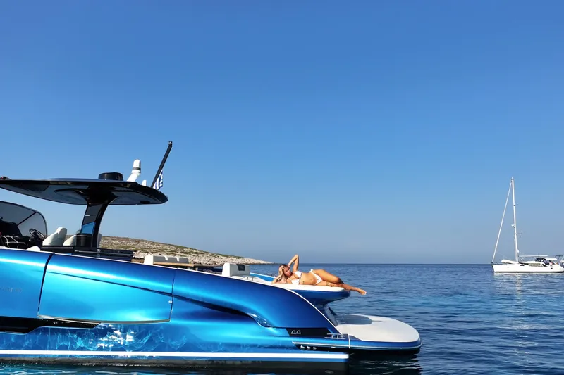 Aegean Infinity Yacht Photos Pics 2023 Solaris Power 44 Open yacht on serene blue sea with sunbather.