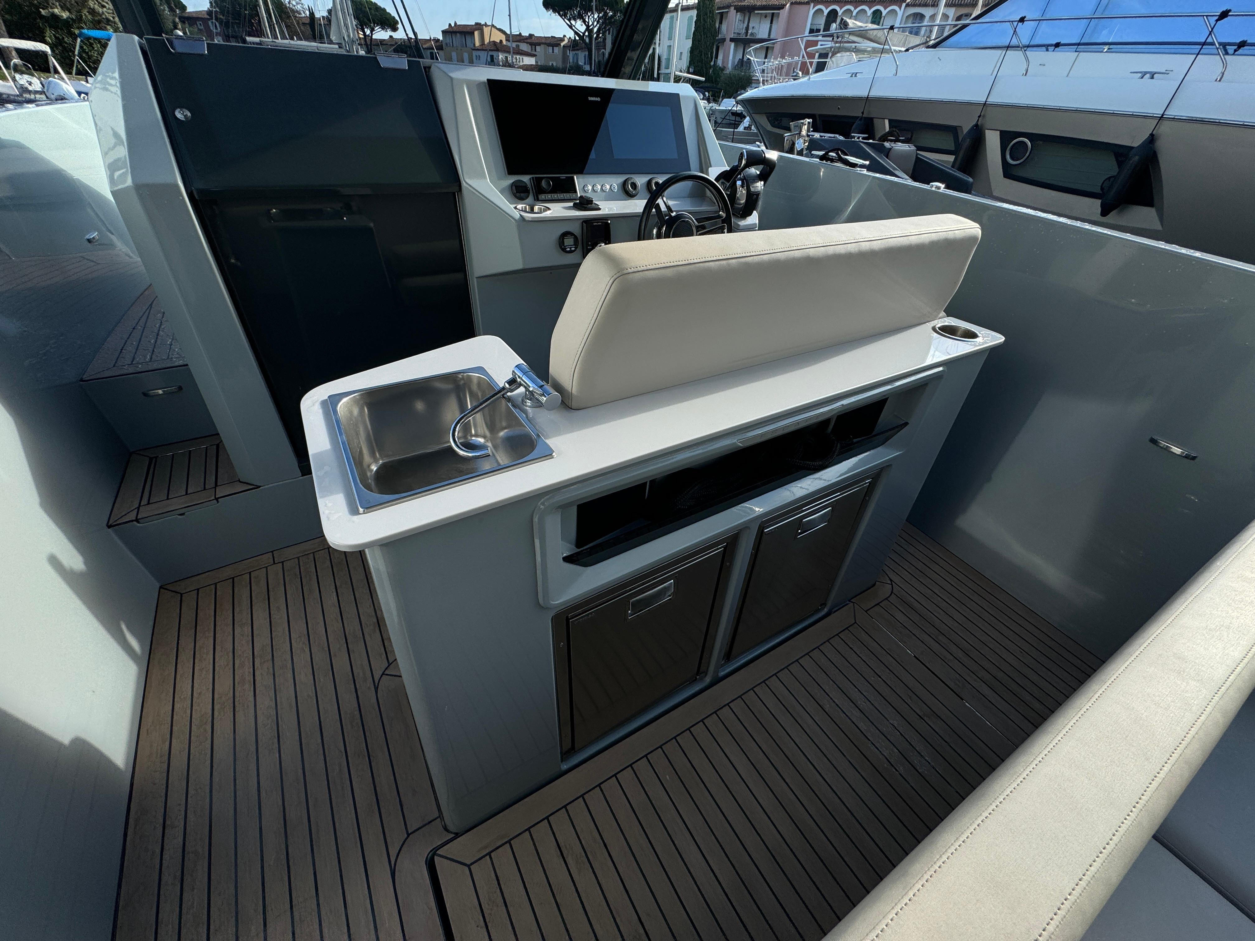 2022 Rand Escape 30 boat interior with helm, sink, and seating area.