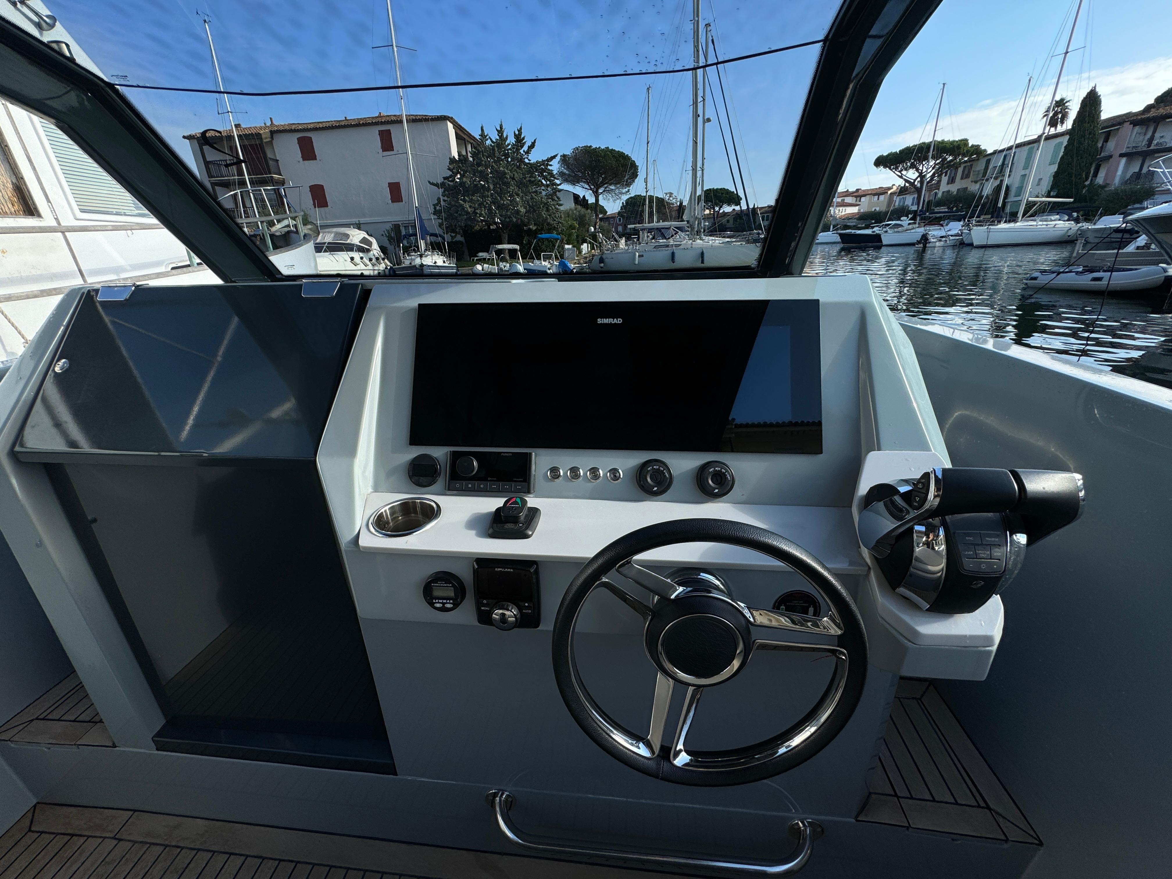 Helm of 2022 Rand Escape 30 boat with modern controls and steering wheel.