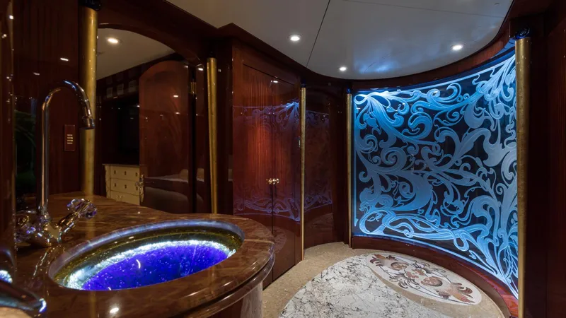 Touch Yacht Photos Pics Luxurious yacht interior with ornate blue-lit wall, elegant sink, and rich wood finishes, Custom Louisbourg 2004.