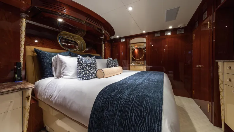 Touch Yacht Photos Pics Luxurious yacht bedroom with elegant bedding, rich wood paneling, and ambient lighting, Custom Louisbourg 2004.