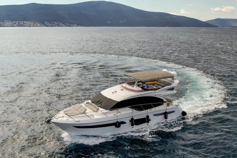 Yacht Photos Pics Luxurious 2019 Princess F55 yacht cruising on open water with scenic mountain backdrop.