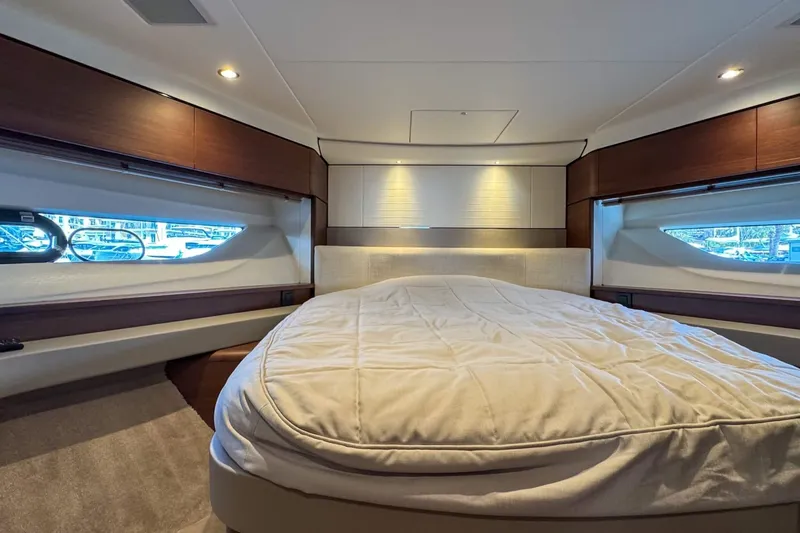  Yacht Photos Pics Luxurious bedroom interior of 2019 Princess F55 yacht with elegant wood accents.