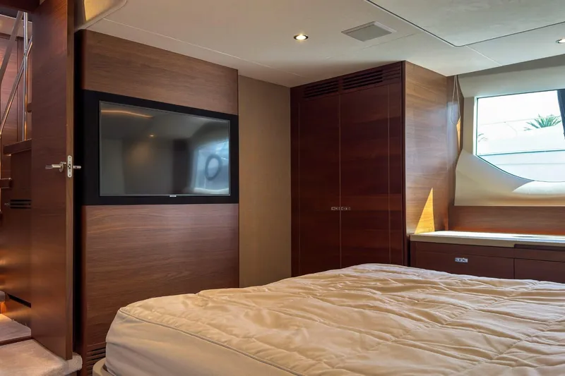  Yacht Photos Pics Luxurious 2019 Princess F55 yacht bedroom with TV, wood paneling, and window view.