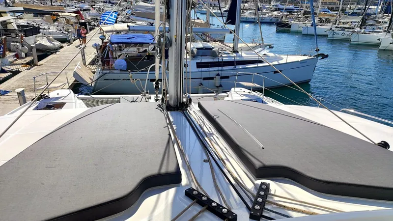  Yacht Photos Pics 2024 Lagoon 51 catamaran docked at marina, surrounded by other boats.
