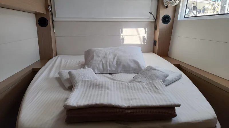  Yacht Photos Pics Cozy cabin bed in 2024 Lagoon 51 yacht with neatly arranged linens.