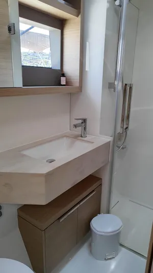  Yacht Photos Pics 2024 Lagoon 51 yacht bathroom with modern sink, shower, and storage.