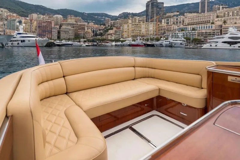 Visionnaire Yacht Photos Pics Luxurious J Craft Torpedo 42 yacht interior with tan leather seating, docked in a scenic marina.