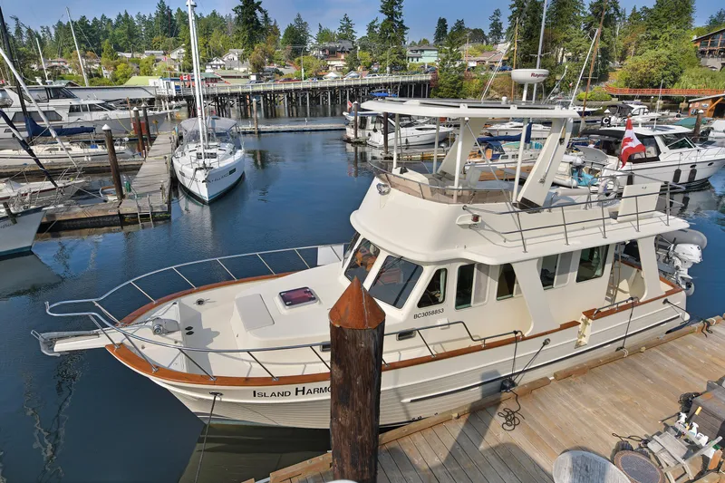 Island Harmony Yacht Photos Pics 2012 North Pacific NP 38 Sedan docked at a marina, surrounded by other boats.