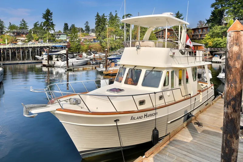 Island Harmony Yacht Photos Pics 2012 North Pacific NP 38 Sedan docked in a scenic marina setting.