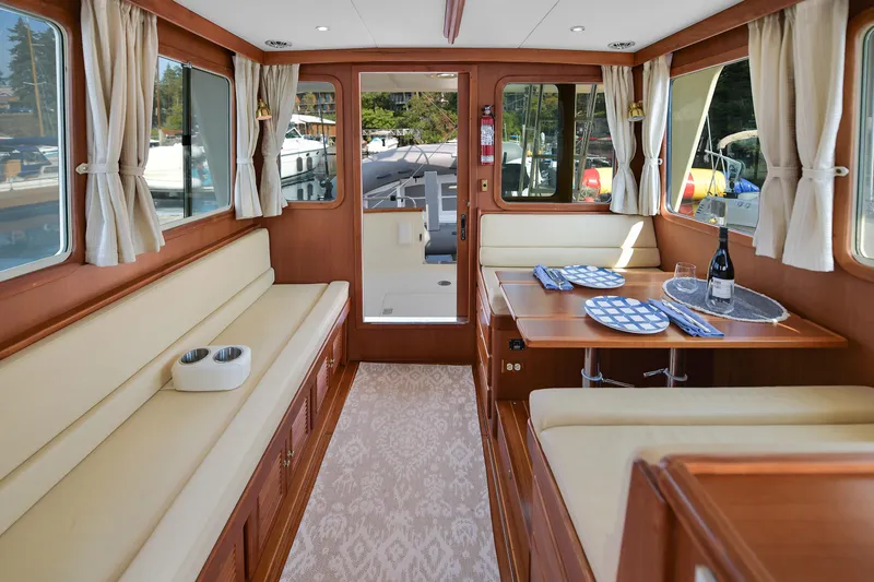 Island Harmony Yacht Photos Pics Interior of 2012 North Pacific NP 38 Sedan with elegant dining setup and cozy seating.