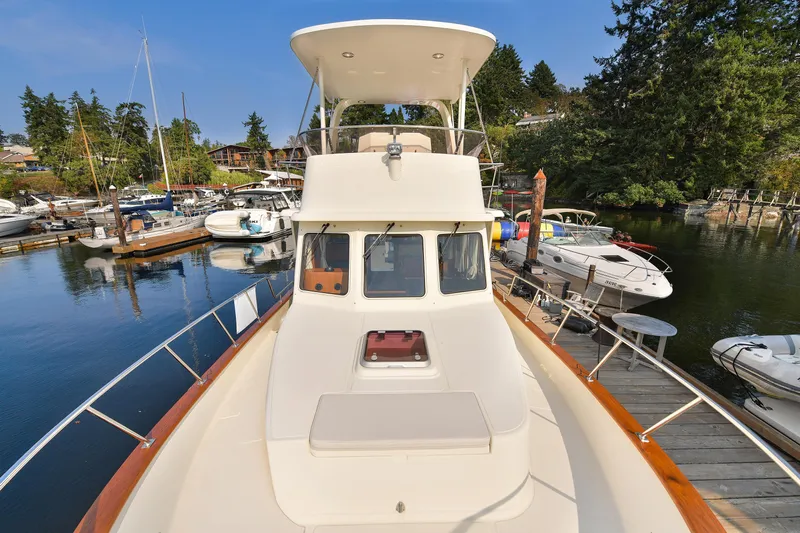 Island Harmony Yacht Photos Pics 2012 North Pacific NP 38 Sedan yacht docked at a marina, surrounded by boats and trees.