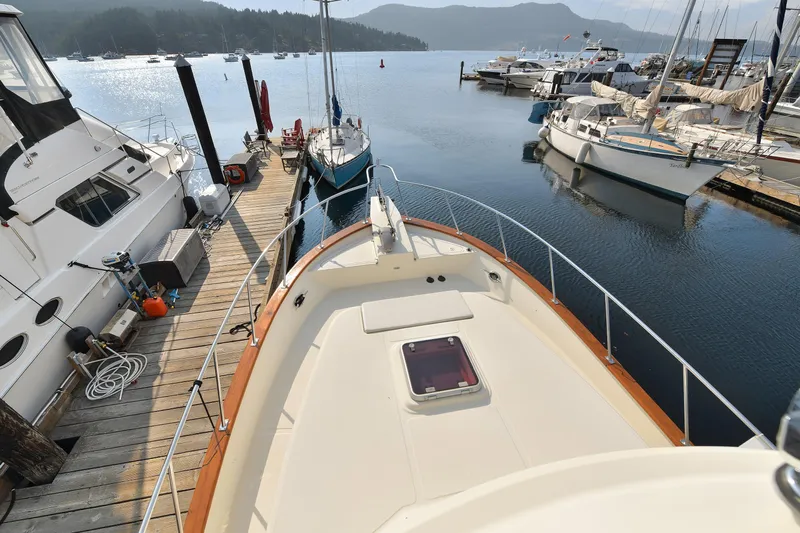 Island Harmony Yacht Photos Pics 2012 North Pacific NP 38 Sedan docked at a scenic marina with surrounding boats.