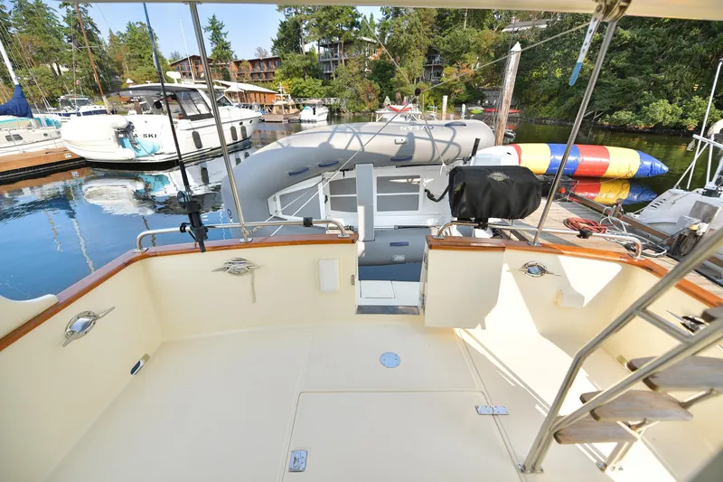 Island Harmony Yacht Photos Pics 2012 North Pacific NP 38 Sedan yacht deck at marina, surrounded by boats and lush greenery.